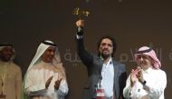 Saudi actor Mohammed Al-Qess waves his award for best actor in the film 