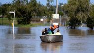 A family uses a boat to get to their house through floodwaters created by Cyclone Debbie in Rockhampton, Australia, April 4, 2017. AAP/Dan Peled/via REUTERS