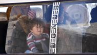 Syrians who fled the city of Aleppo due to the fighting are seen inside a vehicle as they prepare to return to their hometown under the supervision of members of the Russian Military police in the northern city of Manbij on April 5, 2017. / AFP / George O