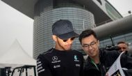 Mercedes' British driver Lewis Hamilton signs an autograph for a Chinese fan in the paddock in Shanghai on April 6, 2017, ahead of the Formula One Chinese Grand Prix. / AFP / Johannes EISELE
