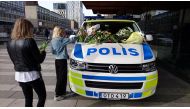 A woman puts flowers on a police vehicle near the Ahlens department store following Friday's attack in central Stockholm, Sweden, April 9, 2017. REUTERS/Philip O'Connor.