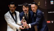 Hong Kong actor Gordon Lam (C) celebrates with fellow actors Philip Keung (R), right, and Richie Ren after Lam won the Best Actor award for his film Trivisa at the Hong Kong Film Awards ceremony in Hong Kong on April 9, 2017. AFP / Anthony Wallace