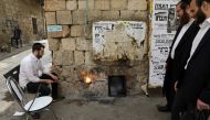 Ultra-Orthodox Jewish men sort their cooking utensils at they dip them in boiling water to remove remains of leaven in preparation for the Jewish holiday of Passover, in Jerusalem's Mea Shearim neighbourhood April 9, 2017. REUTERS/Ammar Awad