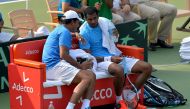 Indian player Ramkumar Ramanathan (R) speaks with his team's non-playing captain Mahesh Bhupathi during a break in his singles match against Uzbekistan's Temur Ismailov at the Davis Cup Asia Oceania group one tie match held between India and Uzbekistan at