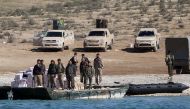 Syrian Democratic Forces (SDF) fighters stand near food supplies on the bank of the Euphrates river, west of Raqqa city, Syria April 10, 2017. REUTERS/Rodi Said
