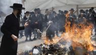 Ultra-Orthodox Jewish men burn leavened items during the Biur Chametz ritual on April 10, 2017 in Jerusalem on the eve of the Jewish Pesach (Passover) holiday, which begins at sunset today. Due to the haste with which the Jews left Egypt, the bread they h