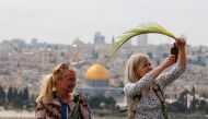 Christian worshippers hold palm fronds and take a photo as they take part in a Palm Sunday procession on the Mount of Olives in Jerusalem April 9, 2017. REUTERS/Amir Cohen
