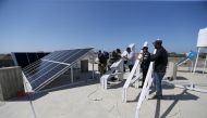 FILE PHOTO: Palestinian workers install solar panels atop the roof of a medical centre in Gaza City, March 1, 2016 (REUTERS / Ibraheem Abu Mustafa) 