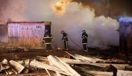 Firefighters extinguish shelters during a fire which destroyed many wood houses at a camp for migrants in Grande-Synthe, near Dunkirk, France, April 11, 2017. REUTERS/Pascal Rossignol.