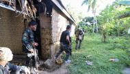 Police and soldiers take position as they engage with the Abu Sayyaf group in the village of Napo, Inabanga town, Bolo province, in the central Philippines on April 11, 2017.   AFP / STR
