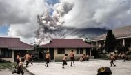 Children play at school as Indonesia's Mount Sinabung spews clouds of smoke and ash on February 10, 2017 (AFP Photo/).