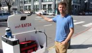 Marble co-founder and chief Matthew Delaney prepares a Happy ground-delivery robot to head off with a load outside the startup's headquarters in San Francisco, California on March 29, 2017.   AFP / Glenn CHAPMAN