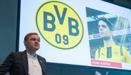 Bjoern Gulden, chairman of sports equipment maker Puma SE, stands in front of a board displaying a picture of Dortmund's injured Spanish defender Marc Bartra during his company's annual general meeting in Herzogenaurach, southern Germany, on April 12, 201