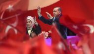 Turkish President Recep Tayyip Erdogan (R) and his wife Emine Erdogan (L) flash the four-finger 