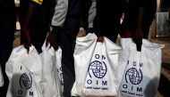 (File Photo) Gambian migrants who voluntarily returned from Libya stand in line with plastic bag from the International Organization for Migration (IOM) as they wait for registration at the airport in Banjul, Gambia April 4, 2017. REUTERS/Luc Gnago