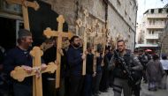 Christian pilgrims carry wooden crosses along the path where Jesus walked, now known as the 