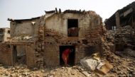 FILE PHOTO: A woman walks out from her house damaged during the 2015 earthquakes in Bhaktapur, Nepal, April 25, 2016 (Reuters / Navesh Chitrakar) 