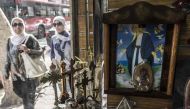 Egyptian women pass by the window of a Coptic Orthodox Churches outside a Christian church-paraphernalia shop displaying crucifixes and icons in the capital Cairo's northern suburb of Shubra, on April 11, 2017.  AFP / KHALED DESOUKI
