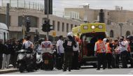 Israeli health team workers treat the wounded British tourist after he was attacked with a knife at a tramway in Jerusalem on April 14, 2017. ( Mostafa Alkharouf - Anadolu Agency ).