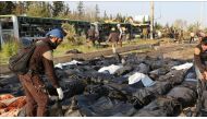 ALEPPO, SYRIA - APRIL 15: Civil defence team members carry dead bodies at the site after bomb-laden vehicle attack held to a convoy, carrying Syrian civilians and opponent forces members those were evacuated from al-Fu'ah and Kefriya districts of Idlib, a