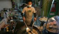 A man prepares food at a street stall in the Phrakanong district of Bangkok. (Photo: AFP/LILLIAN SUWANRUMPHA).