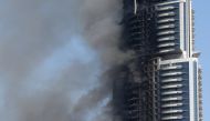 FILE PHOTO: Smoke billowing from the Address Downtown Hotel in Dubai in the aftermath of a huge fire that engulfed several floors of the building on January 1, 2016 (AFP / Marwan Naamani) 