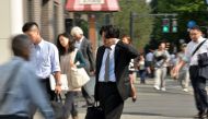 (FILES) This file photo taken on September 30, 2014 shows a Japanese businessman, called salaryman, rubbing his eyes as he heads to his office in Tokyo. AFP / YOSHIKAZU TSUNO