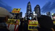 This picture taken on April 13, 2017 shows people holding various placards as they protest against Japan's conservative Prime Minister Shinzo Abe during a rally to denounce his policies and call for his resignation, outside Shinjuku Station in Tokyo. AFP 