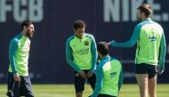 Barcelona's Argentinian forward Lionel Messi (L) chats with Barcelona's Brazilian forward Neymar (2ndL) and Barcelona's defender Gerard Pique (R) during a training session at the Sports Center FC Barcelona Joan Gamper in Sant Joan Despi, near Barcelona on