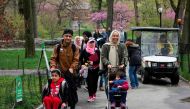 A group of mostly Syrian but some Iraqi refugee families walk through Central Park during a tour of Manhattan April 21, 2017 in New York. AFP / Don Emmert 
