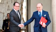 Fench President Francois Hollande (L) shakes hands with French Prime Minister Bernard Cazeneuve as he leaves the weekly cabinet meeting on April 26, 2017 at the Elysee presidential Palace in Paris. / AFP / STEPHANE DE SAKUTIN
