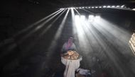 KHAN YUNIS, GAZA - APRIL 19: A Palestinian woman bakes bread by firing pieces of wood and cartons due to power cut and lack of gas in Khan Yunis, Gaza on April 19, 2017. (Abed Zagout - Anadolu Agency)