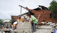 Workers remove debris from a collapsed house after a 6.8-magnitude earthquake hit General Santos City, in southern island of Mindanao on April 29, 2017.   AFP / EDWIN ESPEJO
