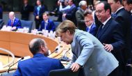 German Chancellor Angela Merkel (centre) speaks with Maltese Prime Minister Joseph Muscat (left) while French President Francois Hollande looks on during a special EU leaders' meeting at the main headquarters of European Council and the Council of the EU,