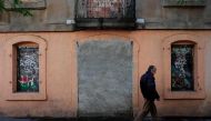 A man passes by a bricked up entrance to a building in Barcelona on April 28, 2017. AFP / PAU BARRENA
