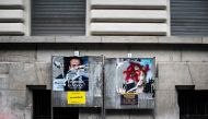 A picture shows vandalised campaign posters of French presidential candidates Emmanuel Macron (L) of the En Marche ! movement and Marine Le Pen (R) of the far-right National Front (FN) in Lyon on May 1, 2017 ahead of the second and final round of the Fren