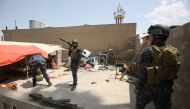 Members of the Iraqi security forces hold a position inside a building on the front line in Mosul's Old City on May 3, 2017, during an offensive to retake the city from Islamic State (IS) group fighters. / AFP / AHMAD AL-RUBAYE