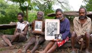 Chief Jack Malia (2nd R) from the Imanourane Tribe holds photographs of Britain's Prince Philip as he sits next to other villagers in the village of Younanen on Tanna Island in the Pacific island nation of Vanuatu, May 6, 2017. REUTERS/Jill Gralow