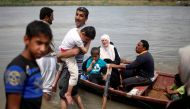 Displaced Iraqis react as others get in a boat to cross the Tigris River after the bridge has been temporarily closed, in western Mosul, Iraq May 6, 2017. REUTERS/Suhaib Salem