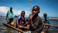 (FILES) This file photo taken on February 16, 2017 shows young Mozambican fishermen returning to the shore after several days of fishing in Palma, where large deposits of natural gas where found offshore. AFP / JOHN WESSELS