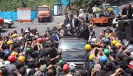 A handout picture provided by the office of Iranian President Hassan Rouhani on May 7, 2017 shows him (C) sitting through the roof of a car, visiting and speaking with coal miners and rescue workers at the scene of a coal mine which suffered from an explo