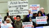 Protesters hold placards as Myanmar's leader Aung San Suu Kyi visits the Guildhall in London, yesterday. 