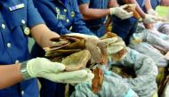 Customs officials hold up seized pangolin scales at Kuala Lumpur airport, Customs complex in Sepang, yesterday.