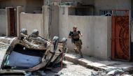 A member of the Iraqi forces runs to take a position in the northwestern al-Haramat neighbourhood of Mosul on May 9, 2017, during the ongoing offensive to retake the area from Islamic State (IS) group fighters.  AFP / FADEL SENNA
