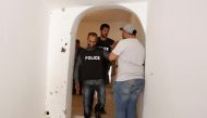 FILE PHOTO: Tunisian police officers pass near a bullet-riddled house damaged during clashes between Tunisian security forces and suspected militants in Tunis, May 11, 2016. REUTERS / Zoubeir Souissi