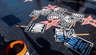 Protest posters are placed at President Donald Trump's star on the Hollywood Walk of Fame as members of Refuse Fascism protest the firing of FBI director James Comey by US President Donald Trump in Los Angeles, California on May 11, 2017. / AFP / RINGO CH