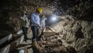 Egyptian Antiquities Minister Khaled el-Enany (C) speaks to the media on May 13, 2017, in front of mummies following their discovery in catacombs in the Touna el-Gabal district of the Minya province, in central Egypt. (AFP / KHALED DESOUKI)