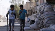 Boys walk near stacked sandbags in the town of Tabqa, after Syrian Democratic Forces (SDF) captured it from Islamic State militants this week, Syria May 12, 2017. Reuters/Rodi Said