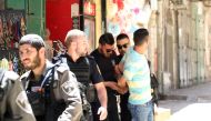Israeli security forces take security take a man who entered into the crime scene as they inspect the crime scene after a Palestinian man was shot dead in an alleged stabbing attack in East Jerusalem, on May 13, 2017. (Mostafa Alkharouf / Anadolu Agency)