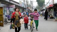 Children use an Ofo's shared bike at a residential area for migrant workers in a village on the outskirts of Beijing, China April 16, 2017. Picture taken April 16, 2017. REUTERS/Jason Lee